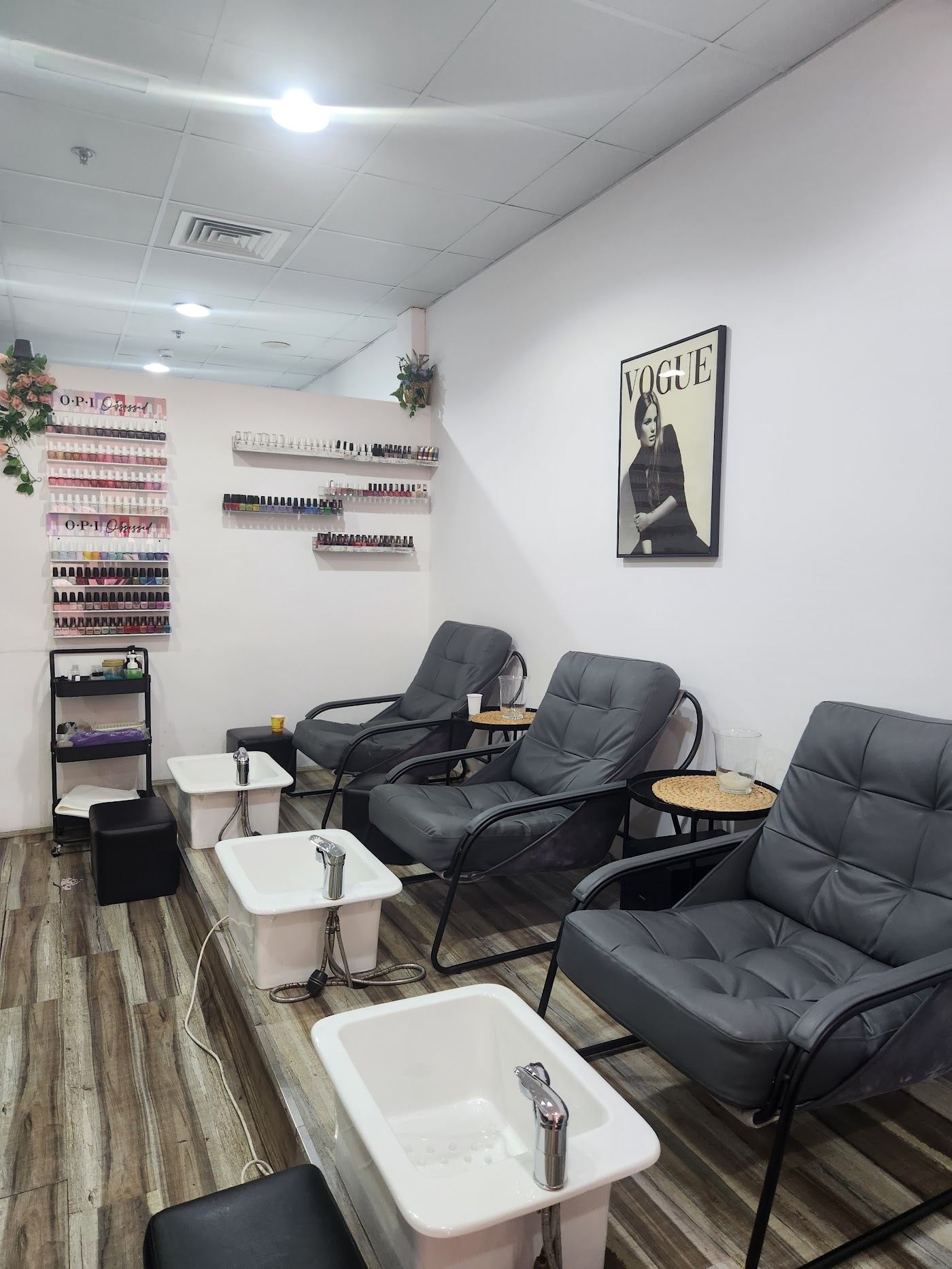 Pedicure lounge at Tabassom Asgari Salon with grey chairs and a wall of nail colours