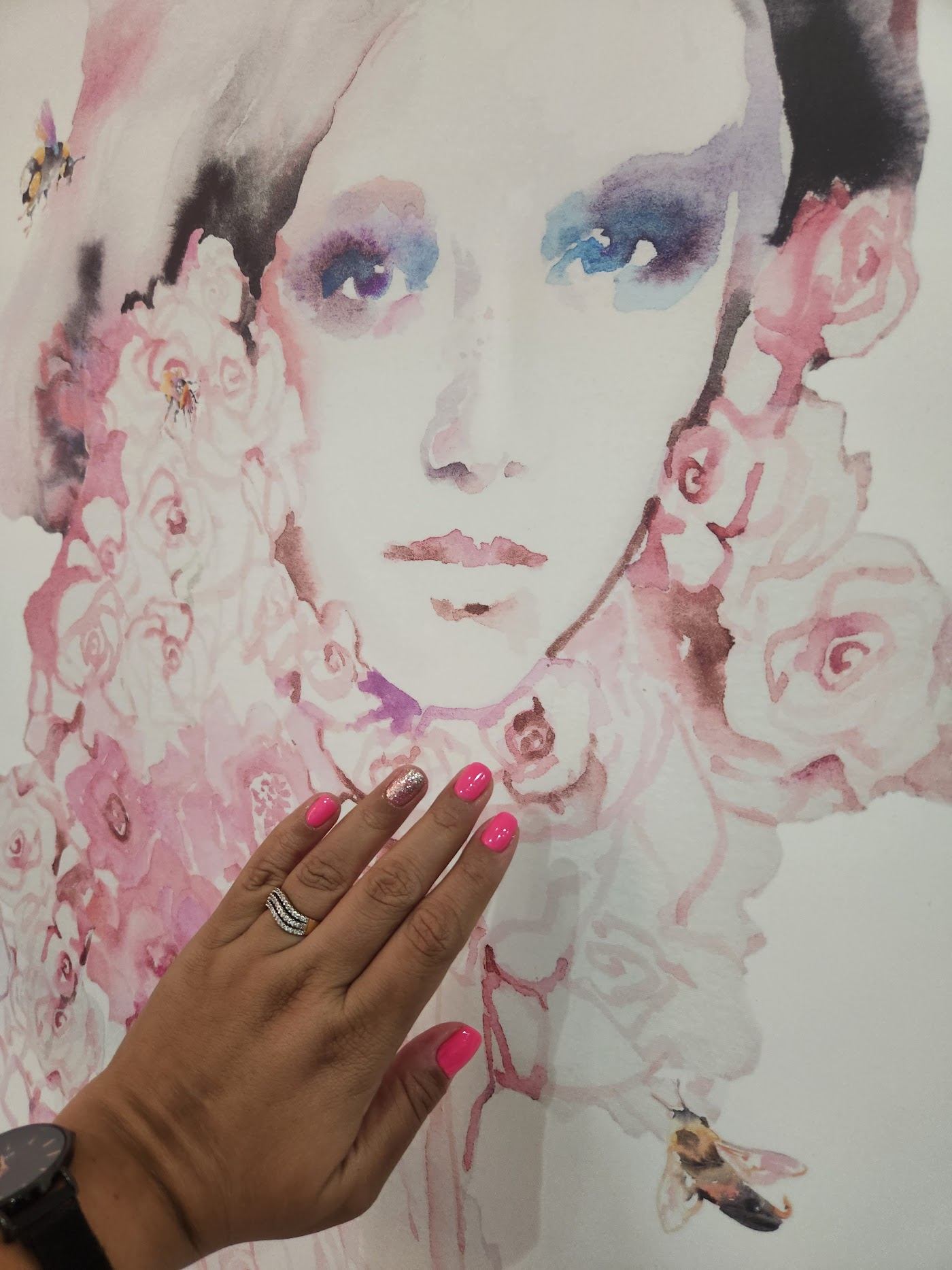 Hot pink gel manicure against the salon's floral mural